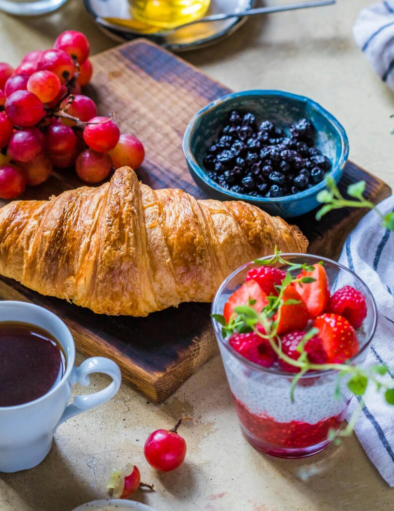 Vibrant breakfast setup featuring a croissant, fresh fruit, and coffee.